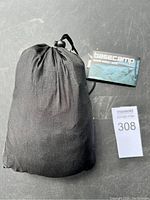 Black drawstring storage sack containing the hammock and straps, with Basecamp tag visible