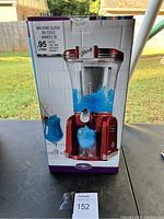 Front box view of the slush drink maker showing the full unit with slush and a glass of blue slush.