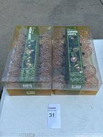 Four boxes of garden string lights with copper wire spherical cages, packaged in clear plastic boxes with green labels