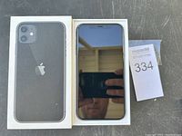 iPhone 11 in box, showing front screen off and rear case.