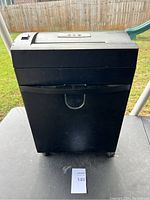 Front view of large black paper shredder with pull-out bin and control panel on top.