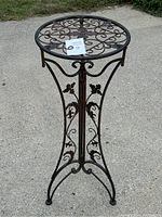Side view of the 36-inch tall metal plant stand showing ornate scrollwork and butterfly accents.