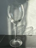 Single Bohemian glass wineglass showing etched decoration and ornate stem detail.