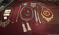 Top-down image displaying an assortment of necklaces, bracelets, earrings, and rings with varying styles and materials.
