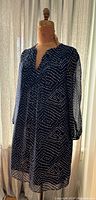 Full view of navy blue Diane Von Furstenberg shift dress with white dotted pattern on mannequin showing length and sleeve style.