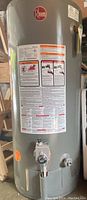 Front view of Rheem water heater with warning labels and control valve