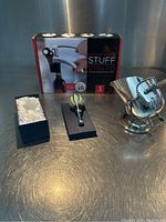 Full lot showing the corkscrew in box, glass stopper in box, and the silver plated wine bottle holder.