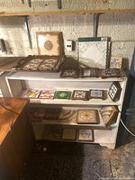 Overview of white shelf with assorted ceramic tiles and tray