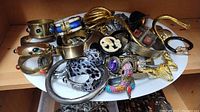 Assorted bracelets, bangles, coil necklace and cameo brooch on white tray
