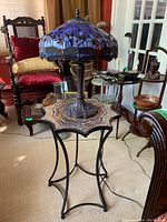 Wide view showing Tiffany style lamp sitting atop star-shaped mosaic side table
