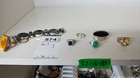 Full lot view: bracelet, pill box and six rings lined up