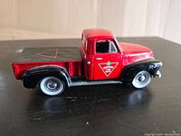Side view of red and black diecast 1952 Chevy truck with Canadian Tire logos visible on the doors.