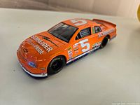 Front angle view of a bright orange 1:24 scale diecast racecar with number 5 and Racing Champions decals.