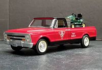 Front angle of red and black 1967 Chevrolet pickup with lawn tractor visible in bed showing detailed grill, tires, and Canadian Tire decal.