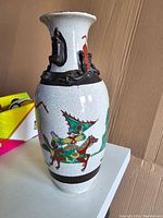 Front view of vintage Chinese porcelain vase with colorful hand-painted warrior on horseback and crackle glaze.