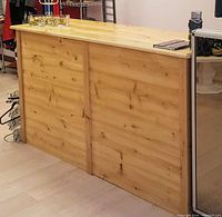 Full view of cedar counter showing closed face front and smooth top surface with some retail items placed on top.