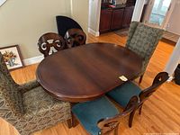 Oval table with chairs arranged around; dark wood finish visible