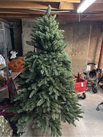 6.5 foot artificial Christmas tree standing assembled in basement