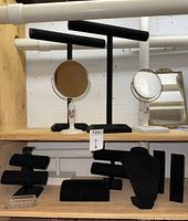 Shelving with jewelry display stands and vanity mirrors showing black velvet stands and floral ceramic-based mirrors