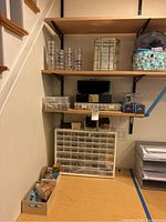 Shelving overview showing stackable organizers, multi-drawer cabinet, bins and wooden tray with supplies