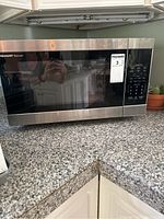 Front view of Sharp Carousel microwave showing stainless steel finish and black glass door.