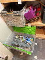 Partially opened plastic bin showing more LEGO pieces and base plates inside.