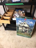 Full view of the Presidents Choice Victorian Style Wooden Dollhouse kit box with small wooden shelf and bagged dollhouse furniture pieces.