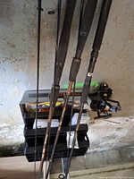 Overhead view of four rods, three reels, and tackle box with compartments open