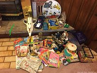 Overview of lots including toys, books, small vehicles, and terrarium.