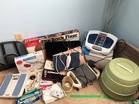 Overview of medical and health items including foot massager, scales, crutches, heating pads, and green plastic container