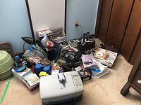 Photo of the lot with HP printer, phones, office supplies scattered on the floor including cables, tape, folders