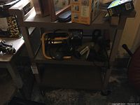 Full view of the Rubbermaid rolling utility cart loaded with assorted items on the top shelf to illustrate size and usage.