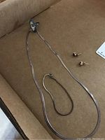 Four 925 silver jewelry pieces: necklace, bracelet, stud earrings with amethyst-colored stones.