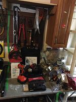 Overview of tool assortment on workbench and pegboard showing cordless drills, hardware, and power tools