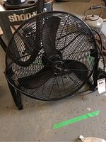 Full front view of black 22-inch electric utility fan with metal blades and protective grill.