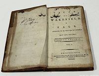 Front view of open book showing title page with handwritten markings and worn edges.