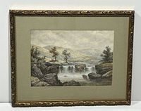 Full view of framed watercolour painting showing landscape with waterfall and rocks, beige-green mat, ornate gold-tone frame.