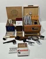 Full collection of tobacciana items including humidor, cigarette holders, pipes, Zippo lighters, matchboxes, and other related accessories.