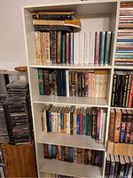 White shelf with top three shelves showing hardcover Tolkien volumes, encyclopedia, letters and Houghton Mifflin white-spine set