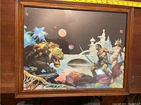 Front view of the framed fantasy art print with a measuring tape showing approximately 16 inches wide.