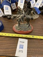 Side view of the knight on horse statue showing detailed armor and shield with tape measure for scale.