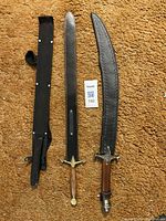 Photo showing both swords fully with their sheaths on carpet background