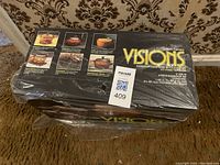 Photo of box showing the Visions rangetop cookware set by Corning in original packaging with photos of pots and pans on box
