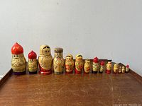 Full set of 14 wooden nesting dolls of various sizes and styles, including the three main Cossak family dolls
