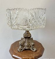 Front side view of the antique crystal centrepiece bowl showing the deep cut and etched floral patterns and ornate metal footed base.