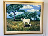 Framed oil painting showing white cow/bull in grassy field, trees and blue sky background