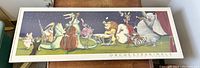 Framed poster with whimsical animal musicians displayed on a wooden surface.