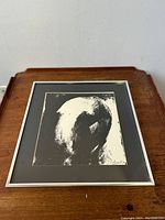 Framed black and white abstract lithograph of a hunched torso, showing overall artwork and frame.