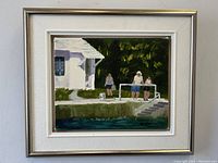 Front view of framed oil painting showing cottage scene with three people near water, with signature visible bottom right.