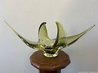 Front view of the green abstract art glass bowl showing its asymmetrical elongated points and organic shape